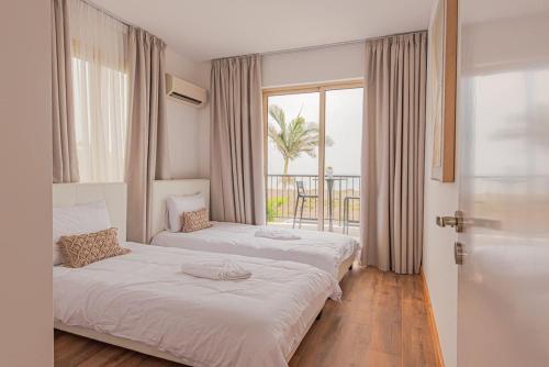 Dos camas en una habitación con vista al mar. en TelMar Royal Villa, en Mazotos