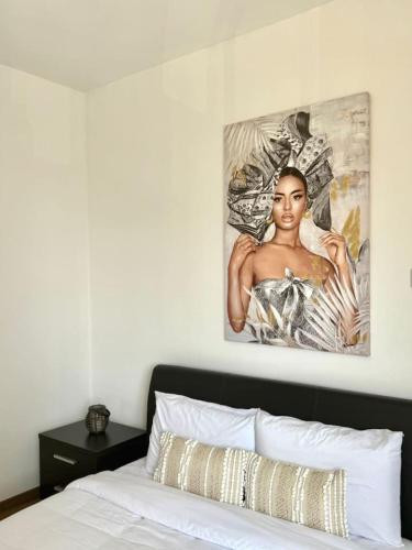 a bedroom with a bed with a painting on the wall at telMar city in Larnaka