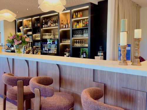 a bar with two chairs sitting at a counter at Mercure Chartres Est in Chartres