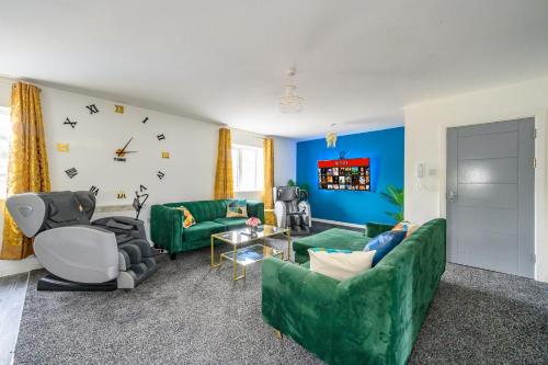 a living room with green couches and a clock at F1TR Luxurious & Comfy Stay in Batley