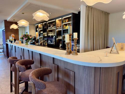 a bar in a room with chairs and a counter at Mercure Chartres Est in Chartres