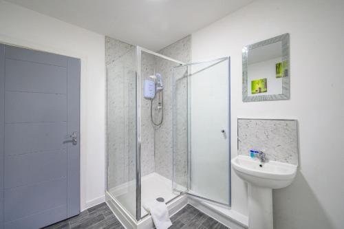 un baño con ducha y lavabo en F1TR Luxurious & Comfy Stay, en Batley