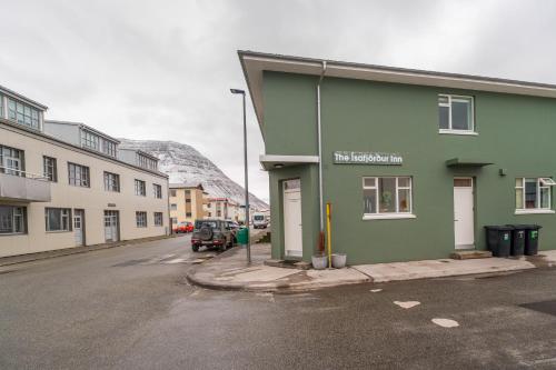 a green building on the side of a street at The Ísafjörður Inn by Ourhotels in Ísafjörður