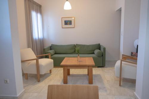 a living room with a green couch and a table at Terra Ionian in Áyios Ilías