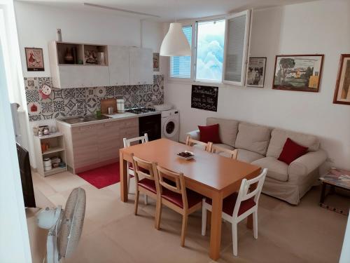 a kitchen and living room with a table and a couch at A Casa di Patty in Marina di Mancaversa