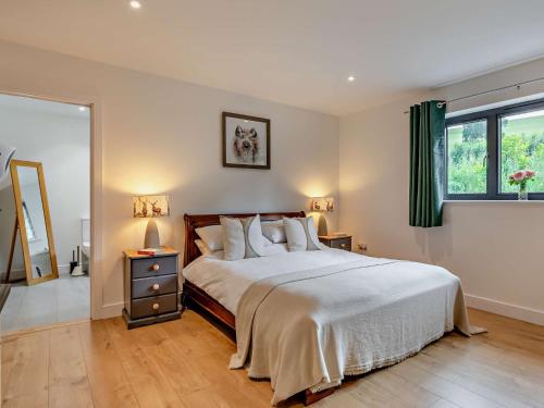 a bedroom with a bed and two lamps and a mirror at 5 Bed in Dulverton 87003 in Morebath