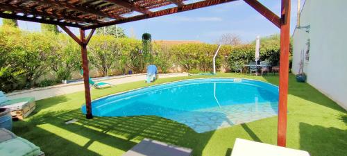 a swimming pool in the yard of a house at Divine ROUJAN Sunny Lodge in Roujan