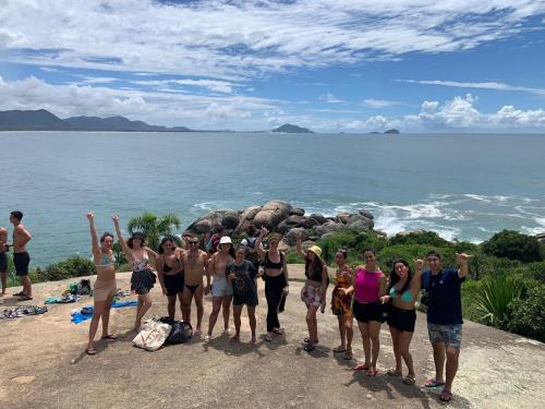 a group of people posing for a picture on the beach at Nômades Vibe da Ilha - Adventure Hostels in Florianópolis
