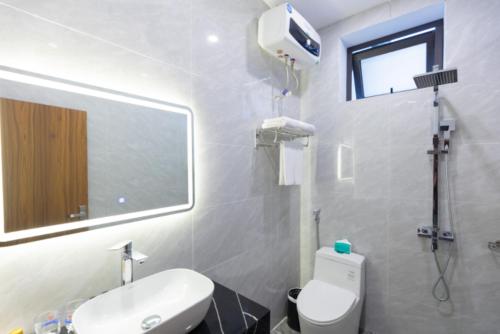 Un baño con inodoro, lavabo y espejo. en Villa Sea 12, en Ðong Thon