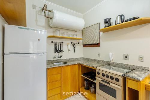 eine Küche mit einem weißen Kühlschrank und einer Spüle in der Unterkunft Apto 300m do lago negro em Gramado/RS RLN0104 in Gramado