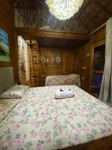 a bedroom with a bed with a floral bedspread at Bangalôs Flecheiras de Canaã in Flecheiras