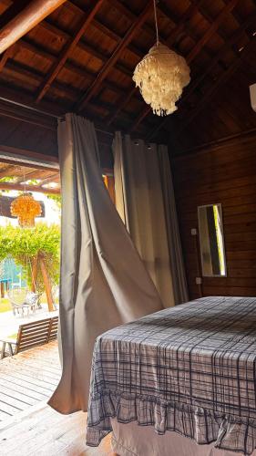 a bedroom with a bed and a chandelier at Bangalôs Flecheiras de Canaã in Flecheiras