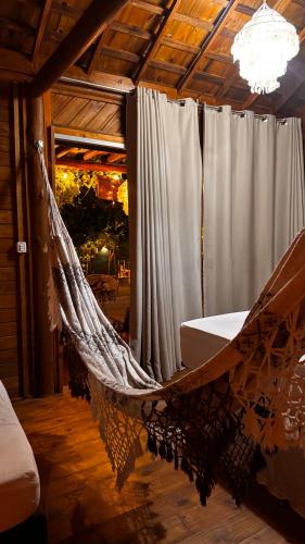 a hammock in a room with a chandelier at Bangalôs Flecheiras de Canaã in Flecheiras