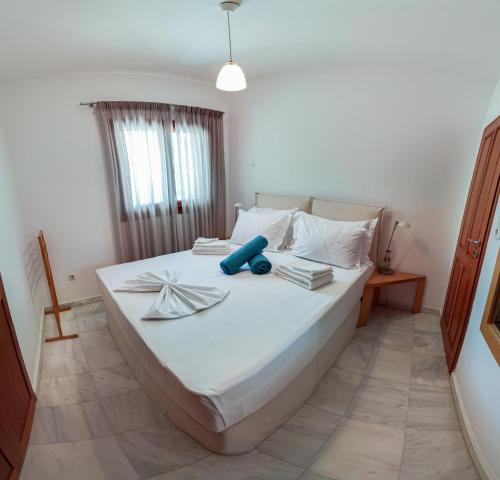 a bedroom with a large white bed with towels on it at Terra Ionian in Áyios Ilías
