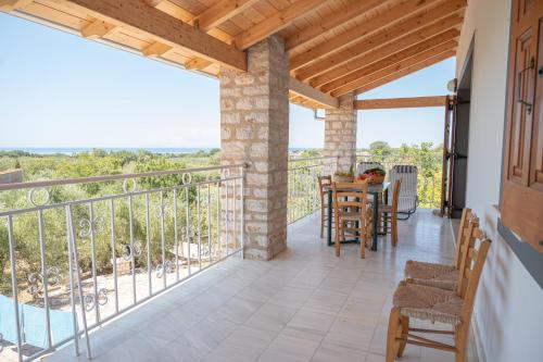 a patio with a table and chairs on a balcony at Terra Ionian in Áyios Ilías