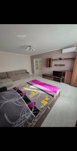 a bedroom with a large bed with a colorful blanket at AirportComfort-TAXI in Chişinău