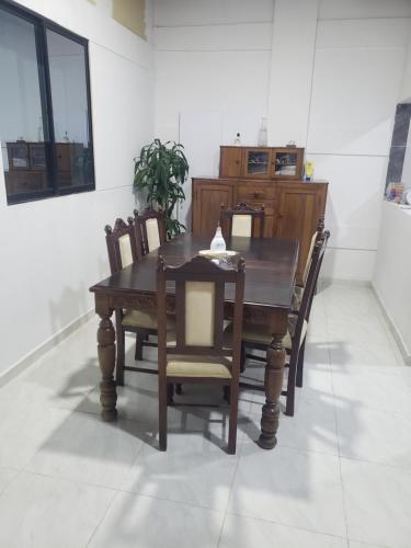 a dining room with a wooden table and chairs at Casa hotel la 33 in Medellín
