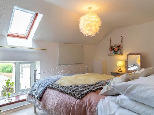 Un dormitorio con una cama y una lámpara de araña. en 2 Bed in South Molton 78303, en Kings Nympton