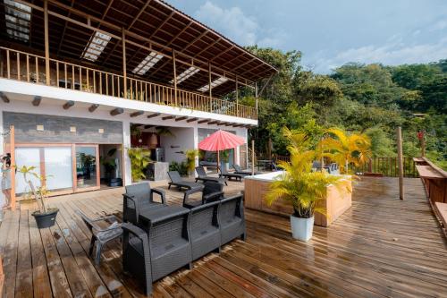 a patio with black chairs and tables on a wooden deck at Cabaña con vista a Santa Marta in Santa Marta