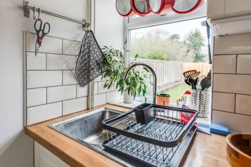 a kitchen sink with a dish drying rack next to a window at Family Home W Patio & Serene Backyard in Oxford