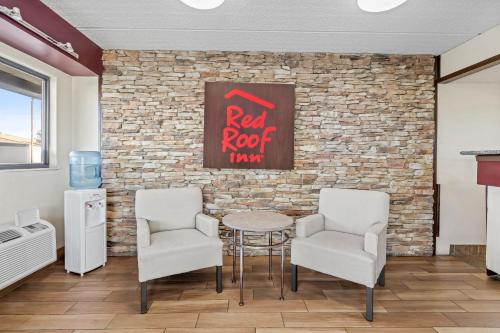 a room with chairs and a table and a brick wall at Red Roof Inn Jackson Downtown - Fairgrounds in Jackson