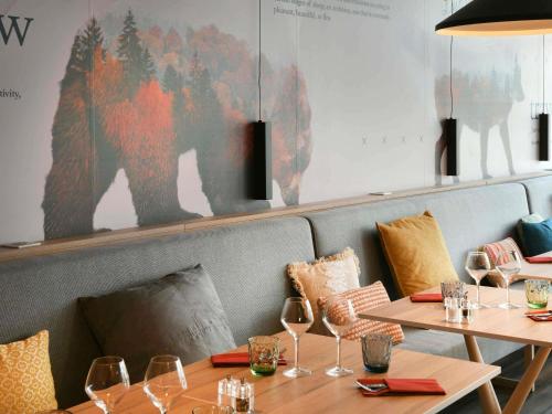 a restaurant with two tables and a bear on the wall at Mercure Annemasse Porte De Genève in Gaillard