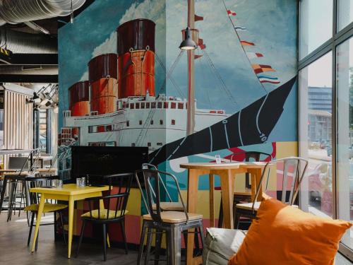 a mural of a ship on the wall of a restaurant at Mercure Le Havre Centre Bassin Du Commerce in Le Havre