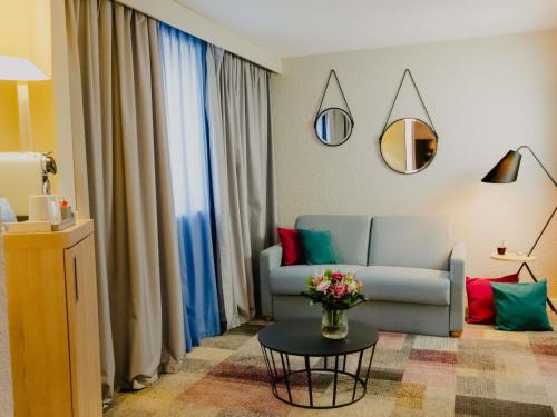 a living room with a couch and a table at Mercure Le Havre Centre Bassin Du Commerce in Le Havre