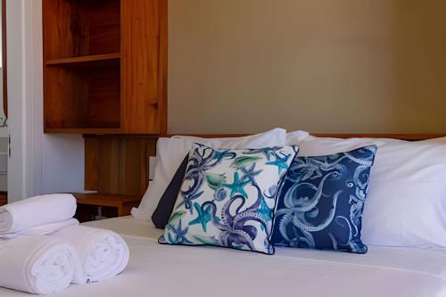 a bed with blue and white pillows on it at MAR DÁ LIBERDADE com Amerigo Vespucci in Morro de São Paulo