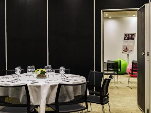 a dining room with a table with wine glasses at Mercure Le Havre Centre Bassin Du Commerce in Le Havre