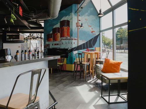 a restaurant with a bar with a ship painted on the wall at Mercure Le Havre Centre Bassin Du Commerce in Le Havre