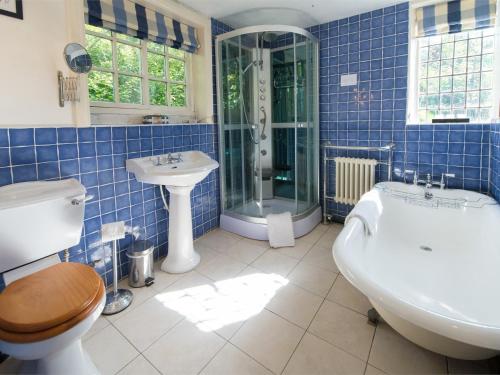 ナレスボロにある4 bed property in Knaresborough HH090の青いタイル張りのバスルーム(バスタブ、シンク付)
