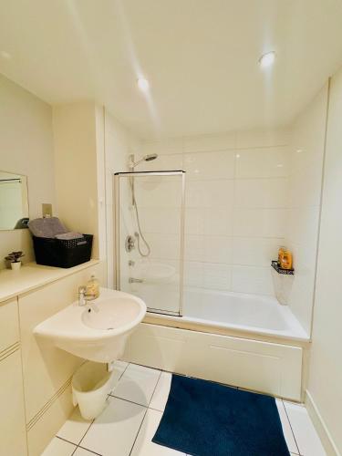 a white bathroom with a sink and a shower at Spacious Room in Cardiff Bay Apartment with Private Bathroom in Cardiff