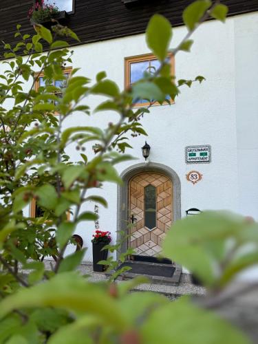 a door to a building with flowers in front at Landhaus Bergfreude in Berwang