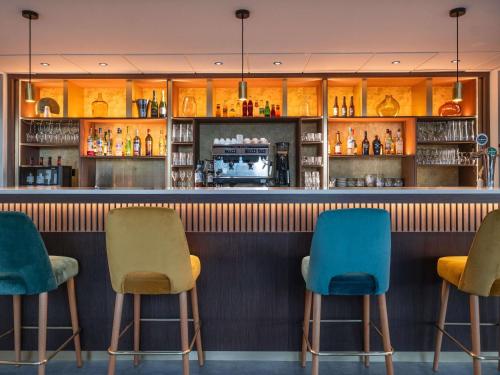 a bar with three chairs and a counter at Mercure Le Mans Batignolles - Hotel & Spa in Le Mans