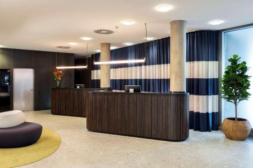 an office lobby with a reception desk and a plant at NH Köln Altstadt in Cologne
