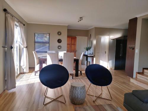 a living room with two chairs and a table at Sunrise Mountains View in Krugersdorp