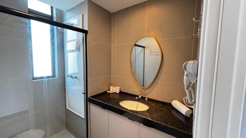 a bathroom with a sink and a mirror at Casa Forte Prince - Flat a 500m do Shopping Plaza by Yolo in Recife
