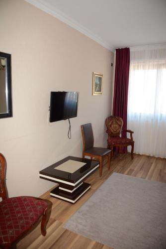 a living room with a tv on the wall at Hotel Ulpiana, Ethno House in Gracanica