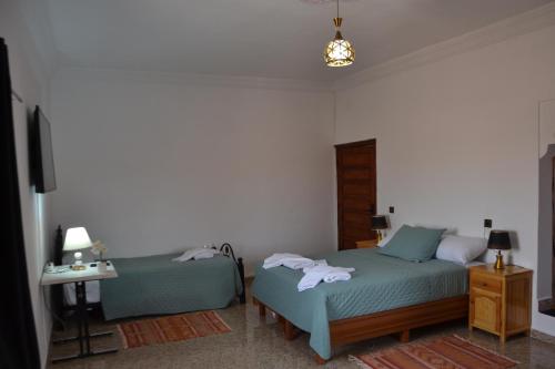 a bedroom with two beds with towels on them at La Belle Vue Guest House in Aït Ben Haddou