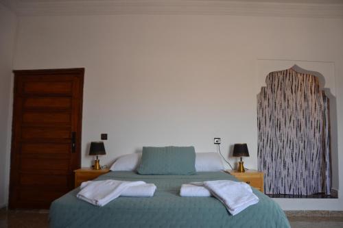 a bedroom with a bed with two towels on it at La Belle Vue Guest House in Aït Ben Haddou
