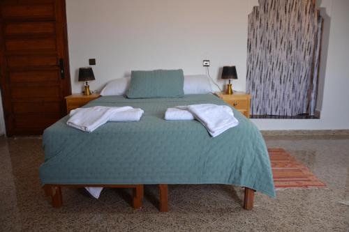 a bedroom with a bed with two towels on it at La Belle Vue Guest House in Aït Ben Haddou