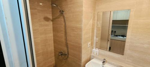 ein Bad mit einer Dusche, einem WC und einem Spiegel in der Unterkunft Springwood Bright Escape Studio in Warungmangga