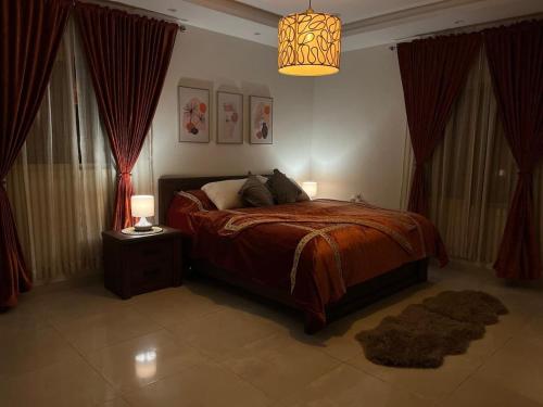 Un dormitorio con una cama y una lámpara de araña. en Elegant apartment close to Al Sariyah roundabout, en Yeda