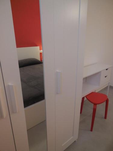 a bedroom with a bed and a desk and a red stool at Villa Cycas in Ischia