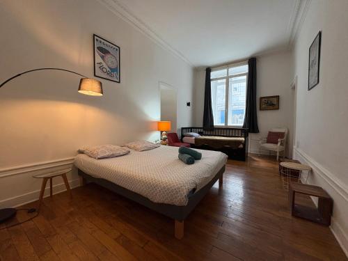 una camera da letto con un letto e un soggiorno di Le Granvelle a Besançon