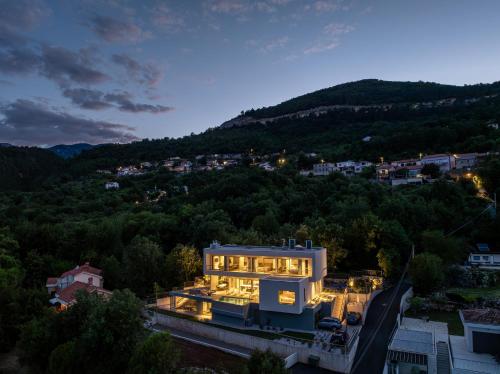 a house with a lot of lights on it at night at Villa Ladeti Sereno in Poljane