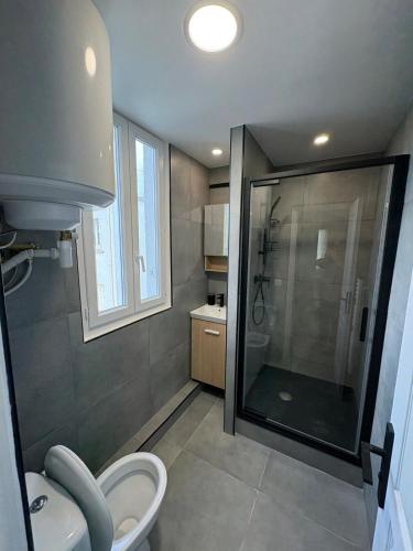 a bathroom with a shower and a toilet in it at Studio cosy station métro Mairie in Aubervilliers