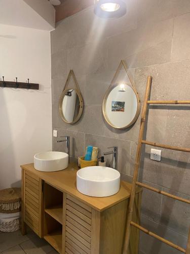 a bathroom with two sinks and two mirrors at Chambres d'hôtes du domaine des doudous in Saint-Pierre