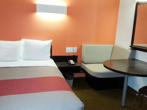 a hotel room with a bed and a chair and a table at Motel 6-Erie, PA in Erie